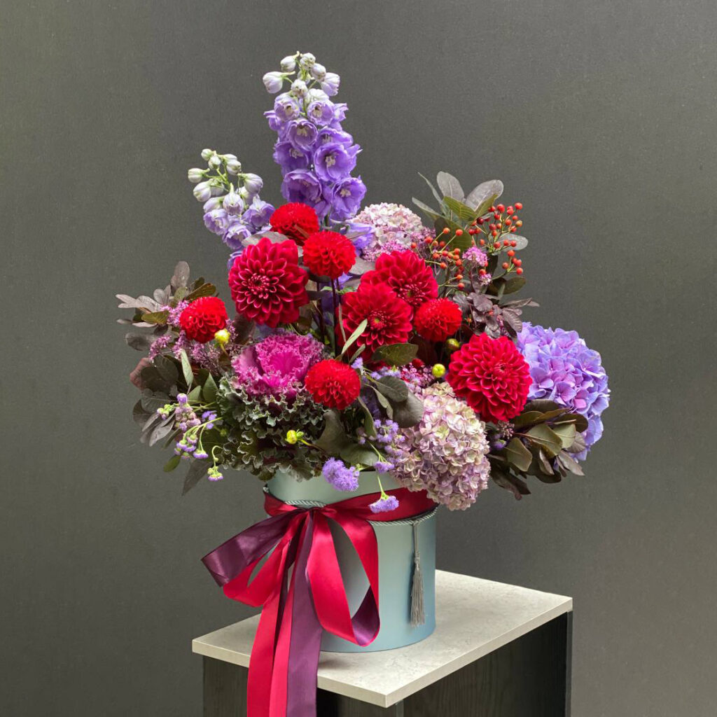 Jasne, kolorowe kwiaty w niebieskim pudełku