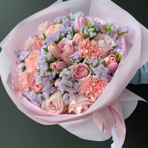 Bukiet „Pudrowe Marzenie” z różami, tulipanami, goździkami i limonium w pastelowych odcieniach różu, ułożony w elegancką kompozycję.